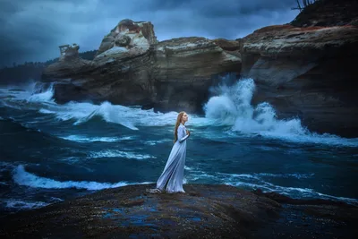 Woman in White Gown Standing on Rocky Shore at Dusk - free wallpaper 2000×1333