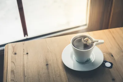Coffee Cup with Tea Bag on Wooden Desk by Window - free food wallpaper 5472×3648