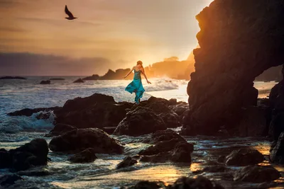 Woman in Turquoise Dress on Rocky Beach at Sunset - free wallpaper 2048×1365