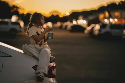 Girl Sitting on Car at Sunset in Parking Lot - free wallpaper 6144×4096