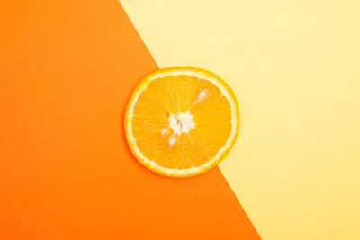 Orange Slice on Divided Orange and Yellow Background - free minimalist wallpaper 5472×3648