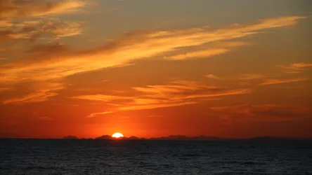 Vibrant Sunset Over Ocean with Mountain Silhouettes - free wallpaper 5120×2880