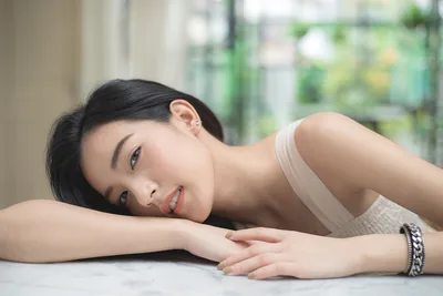 Young Woman Resting Head on Arms Indoors - free wallpaper 2048×1365