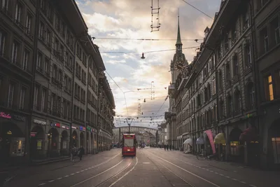 Red Tram on European Street with Clock Tower - free city & urban wallpaper 8688×5792