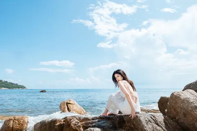 Woman in White Dress Sitting on Rocky Beach - free wallpaper 6000×4000
