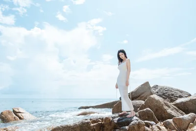 Woman in White Dress Standing on Rocky Coastal Outcrop - free wallpaper 5347×3565