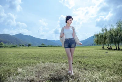 Woman Standing in Meadow with Mountain Backdrop - free wallpaper 6000×4000