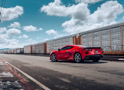Red Sports Car Parked Beside Freight Train - free wallpaper 6186×4480