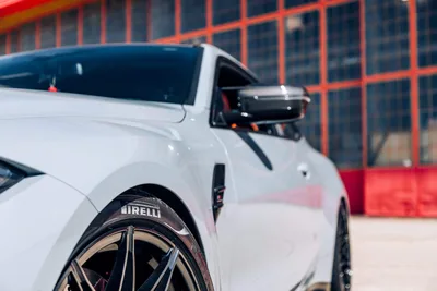 White Sports Car with Pirelli Tires Against Red Building - free cars & vehicles wallpaper 6720×4480