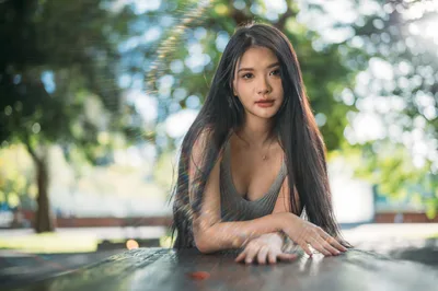 Woman Posing at Outdoor Table in Dappled Sunlight - free wallpaper 4000×2657