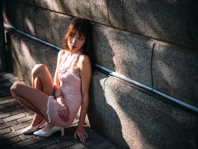 Woman in Pink Dress Sitting Against Stone Wall - free wallpaper 3000×2250