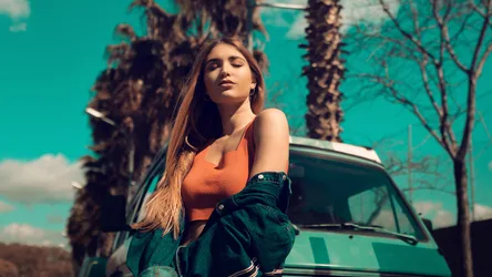 Woman in Orange Top Posing by Turquoise Car - free wallpaper 2048×1152