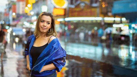 Woman in Blue Jacket on Vibrant City Street at Night - free wallpaper 2048×1152