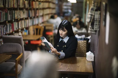 Student Reading in Library Among Bookshelves - free people & portraits wallpaper 4000×2658