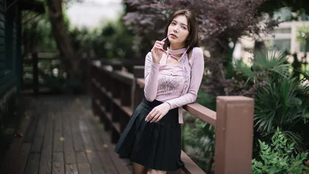 Young Woman Sitting in Lush Garden Pathway - free wallpaper 4000×2249