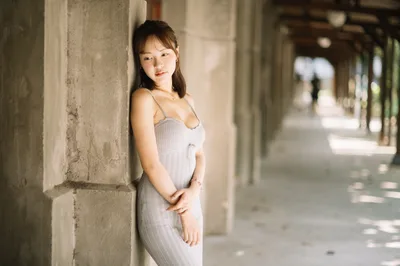 Woman in White Dress Leaning Against Concrete Pillar - free wallpaper 4000×2658