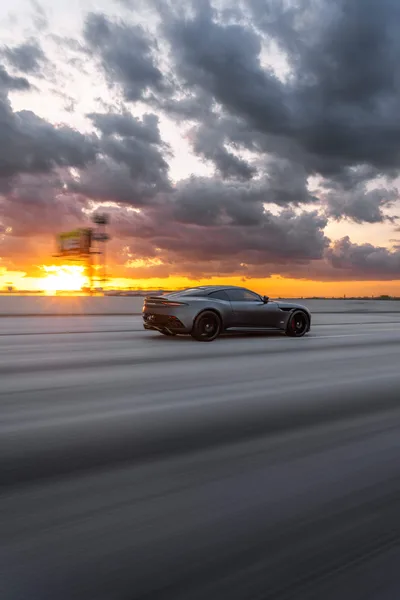 Sports Car on Beach at Sunset with Storm Clouds - free wallpaper 6336×9504