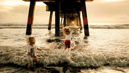 Children Playing in Ocean Waves Under Pier - free people & portraits wallpaper 2000×1125