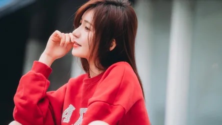Young Woman in Red Sweatshirt Posing Outdoors - free wallpaper 7680×4320