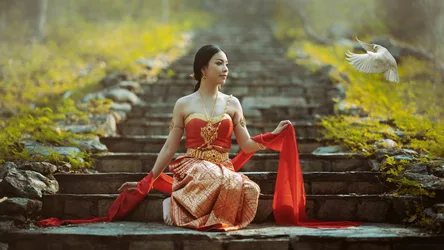 Woman in Red Thai Dress on Ancient Stone Steps - free wallpaper 2048×1152