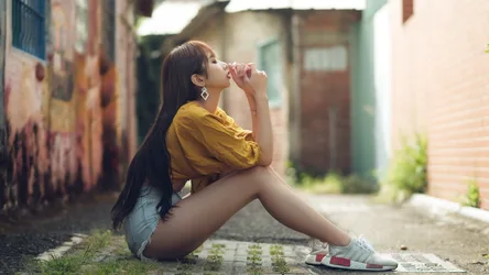 Young Woman in Yellow Shirt Sitting in Urban Alley - free wallpaper 5846×3289