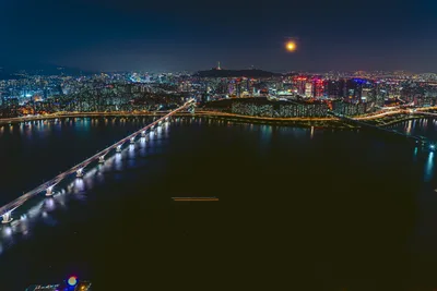 Nighttime Cityscape with Illuminated Bridge Over River - free wallpaper 7680×5123