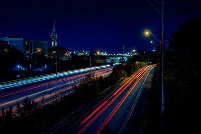 Night Highway Traffic with Illuminated Church Spire - free city & urban wallpaper 7680×5123