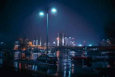 Rainy Night Parking Lot with Modern City Skyline - free city & urban wallpaper 7680×5123