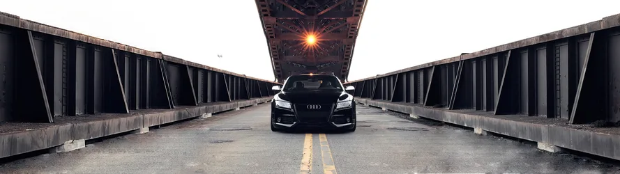 Black Audi A5 Coupe on Industrial Bridge at Sunset - free wallpaper 5120×1440