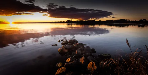 Sunset Over Calm Lake With Rocky Shoreline - free wallpaper 6144×3138