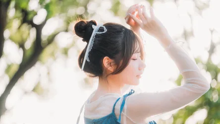 Young Woman with Bun Hairstyle in Sunny Garden - free wallpaper 7680×4321