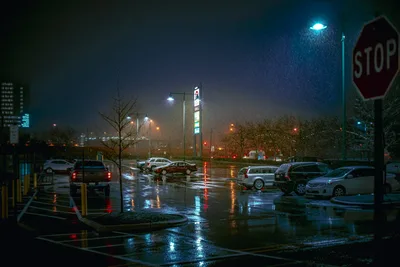 Rainy Night Parking Lot with Cars and Street Signs - free wallpaper 7680×5123
