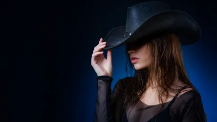 Woman in Black Cowboy Hat Portrait Against Blue Background - free wallpaper 7680×4320