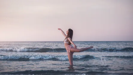 Woman Performing Dance Move in Ocean Waves at Sunset - free wallpaper 2000×1125
